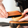 Coffee brush in use to clean around your bean grinder